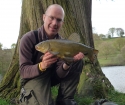 Paul Fletcher 5lbs 1oz Tench from Secret Lake using Enterprise Tackle.. Caught from a pre-baited swim at 40 yards range at the edge of emerging lily pads. Using a 12ft Greys X-Flight Barbel rod,